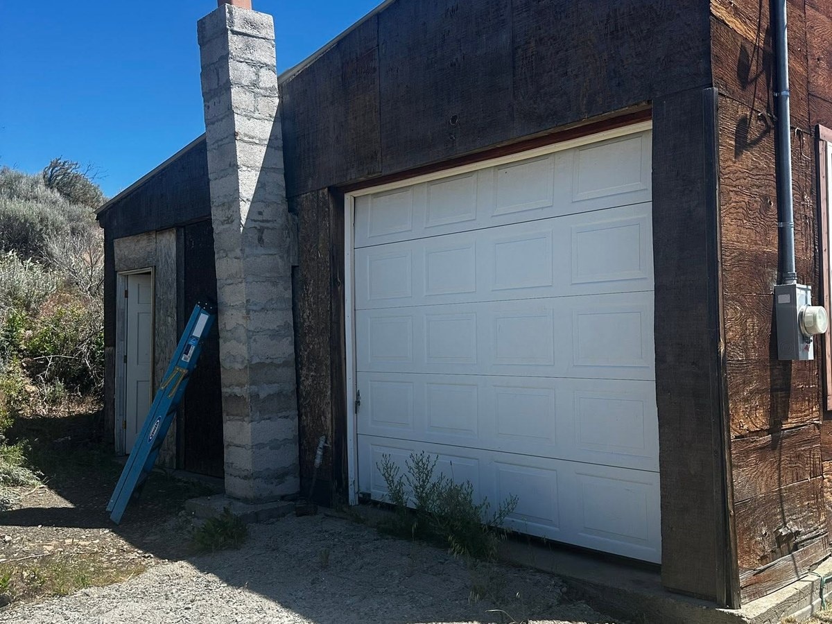 Rural garage clad in weathered board and batten before the rebuild
