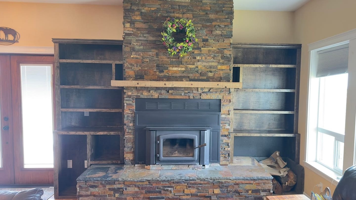 Stone fireplace with dark wood built-in shelving on both sides