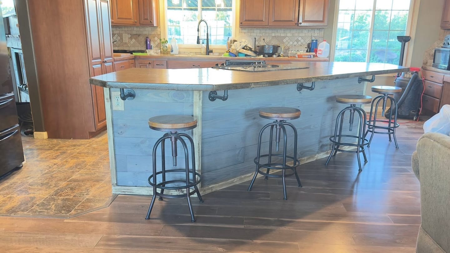 Finished kitchen island with a single-level counter and stools