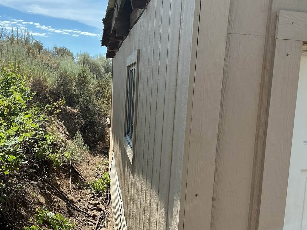 Finished siding running down to meet the hillside