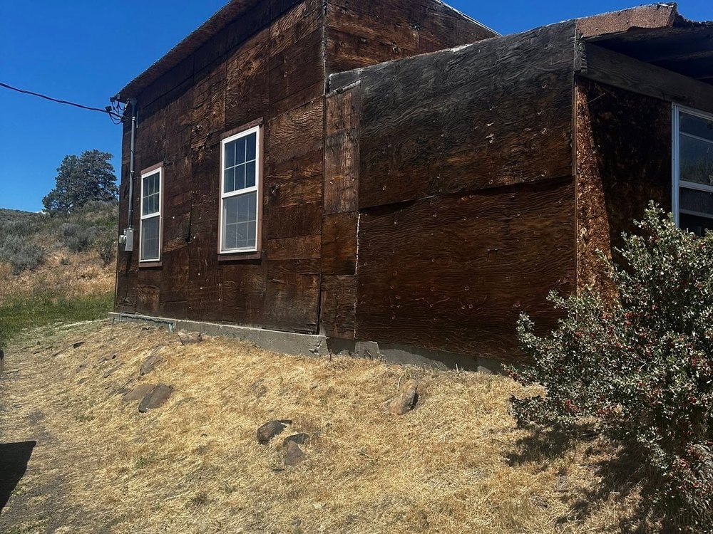 Original garage clad in weathered board and batten, sitting on a sagebrush hillside