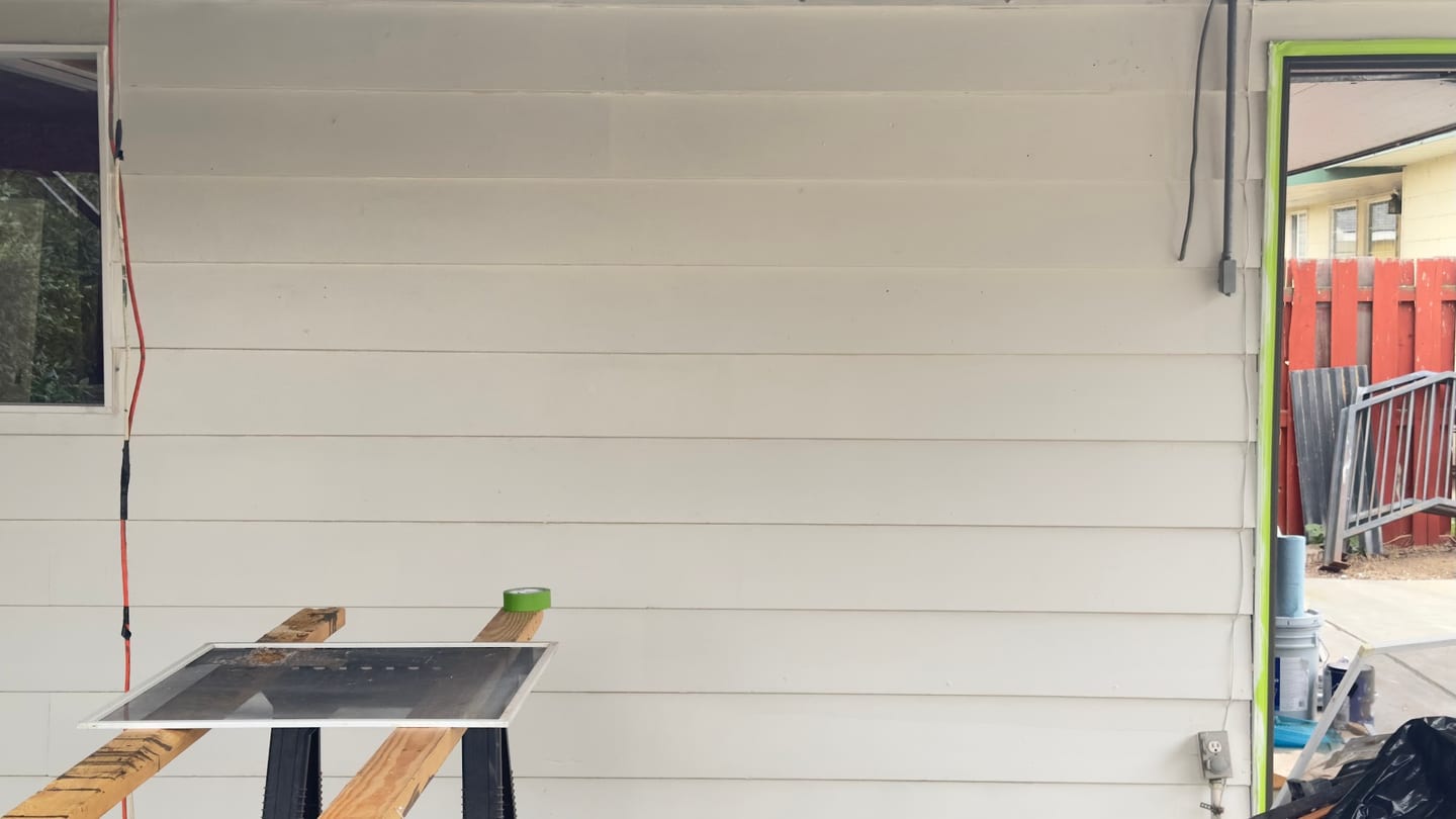 Replacement siding board set out on a level during an exterior repair